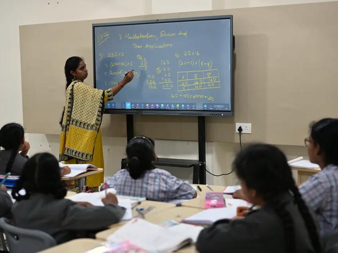 Teacher explaining a lesson Teacher explaining a concept on the interactive smart board to a class